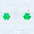 Green clover-shaped earrings with 'lucky' text on a clear background