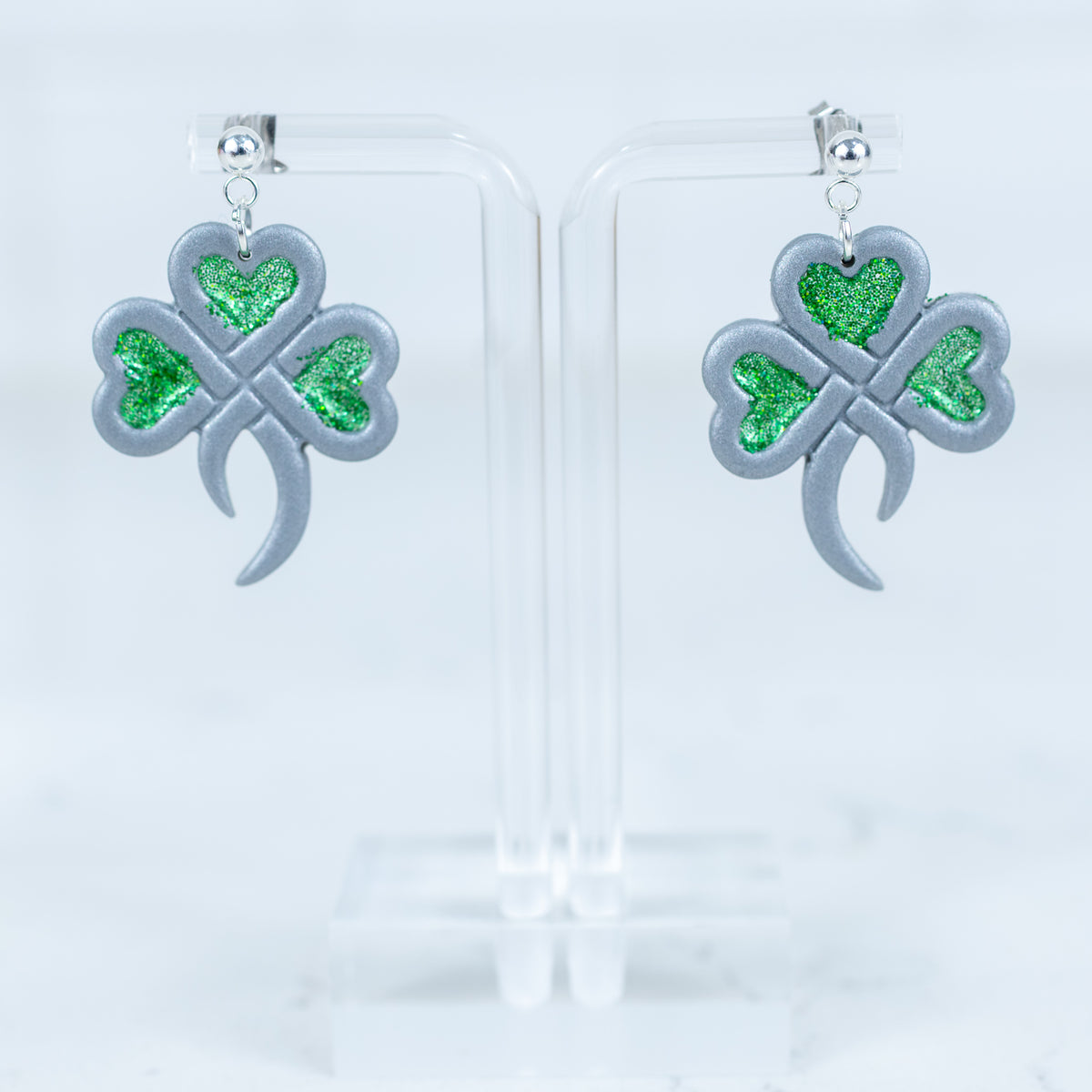 Silver shamrock earrings with green glitter heart accents and silver ball srud