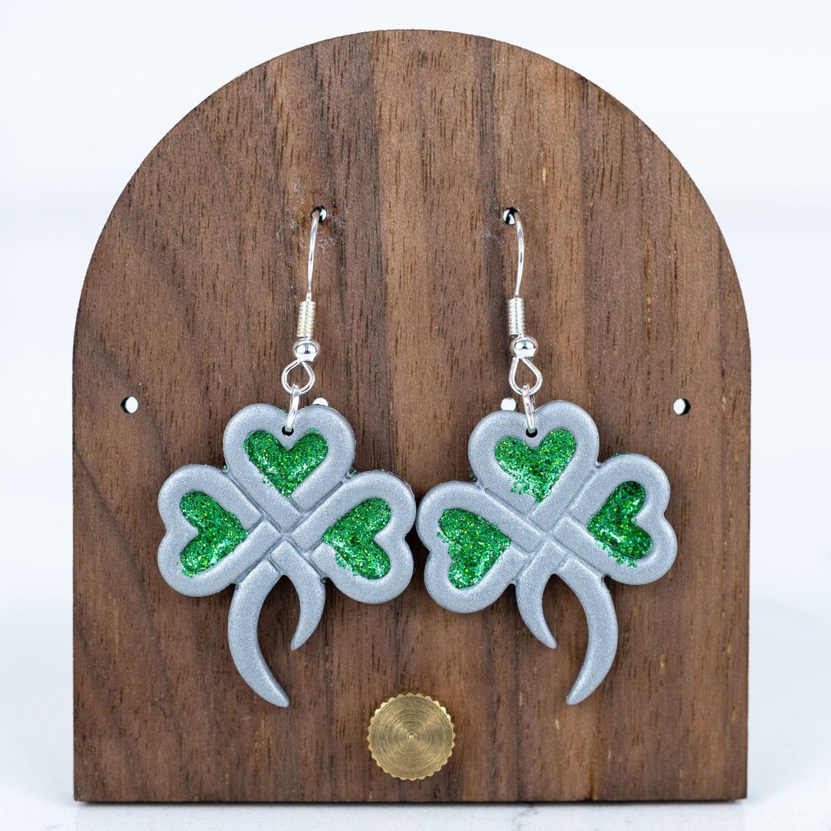 Silver shamrock earrings with green glitter heart accents and silver hooks