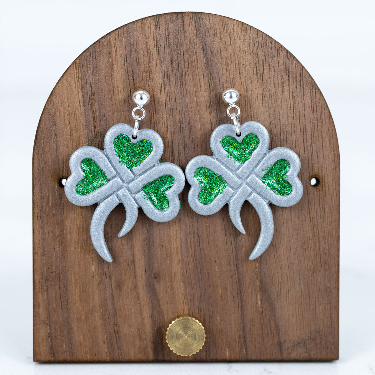 Silver shamrock earrings with green translucent glitter heart accents and silver bal; studs