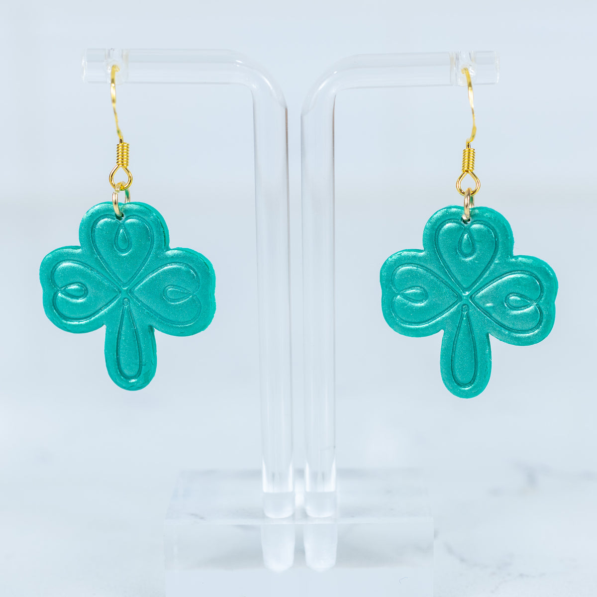 Teal embossed shamrock polymer clay dangle earrings with gold hook hardware