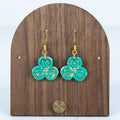 Teal clover earrings with gold accent detailing and gold hook hardware