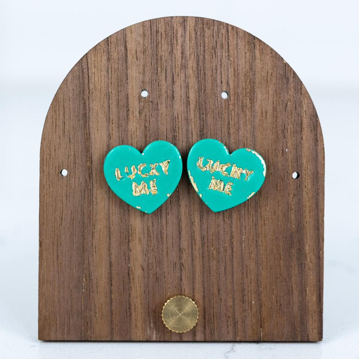 Teal heart stud earrings with gold lucky me text handmade from polymer clay